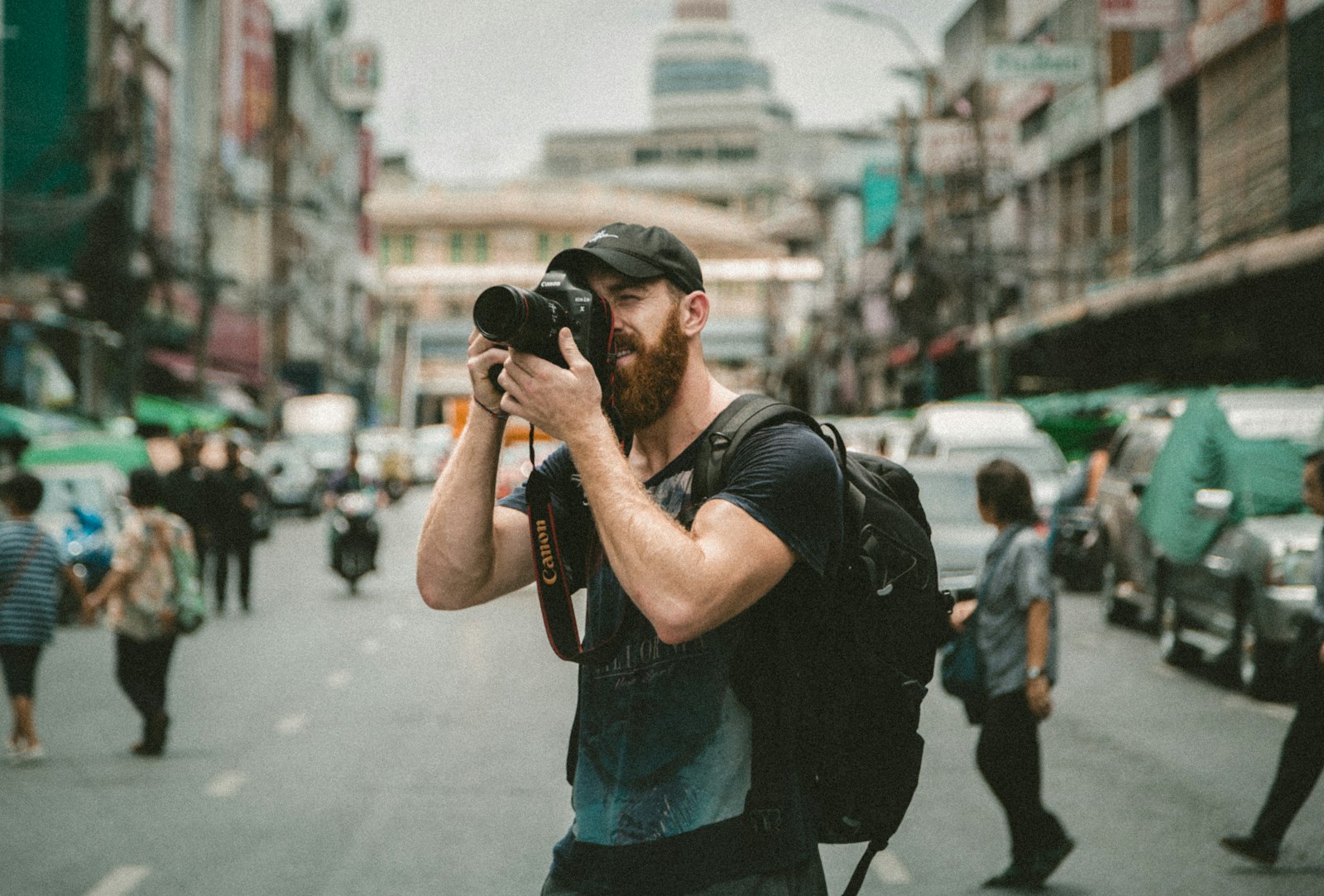 A photojournalist shooting with a long lens on a busy city street